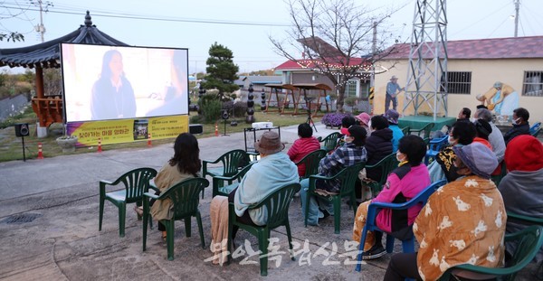 회관 앞에 모여 앉아 마을 영화를 관람하고 있는 회포마을 주민들                                                                                   사진 / 김정민 기자