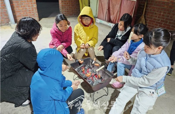 캠핑스쿨에 참가한 아이들이 바비큐를 하며 소떡구이를 손수 구워먹고 있다